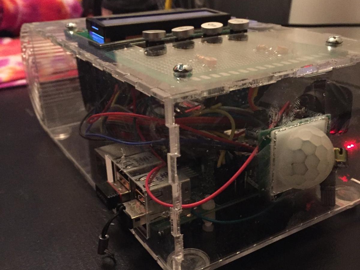 The finished alarm clock from the front corner, with the motion sensor dome visible