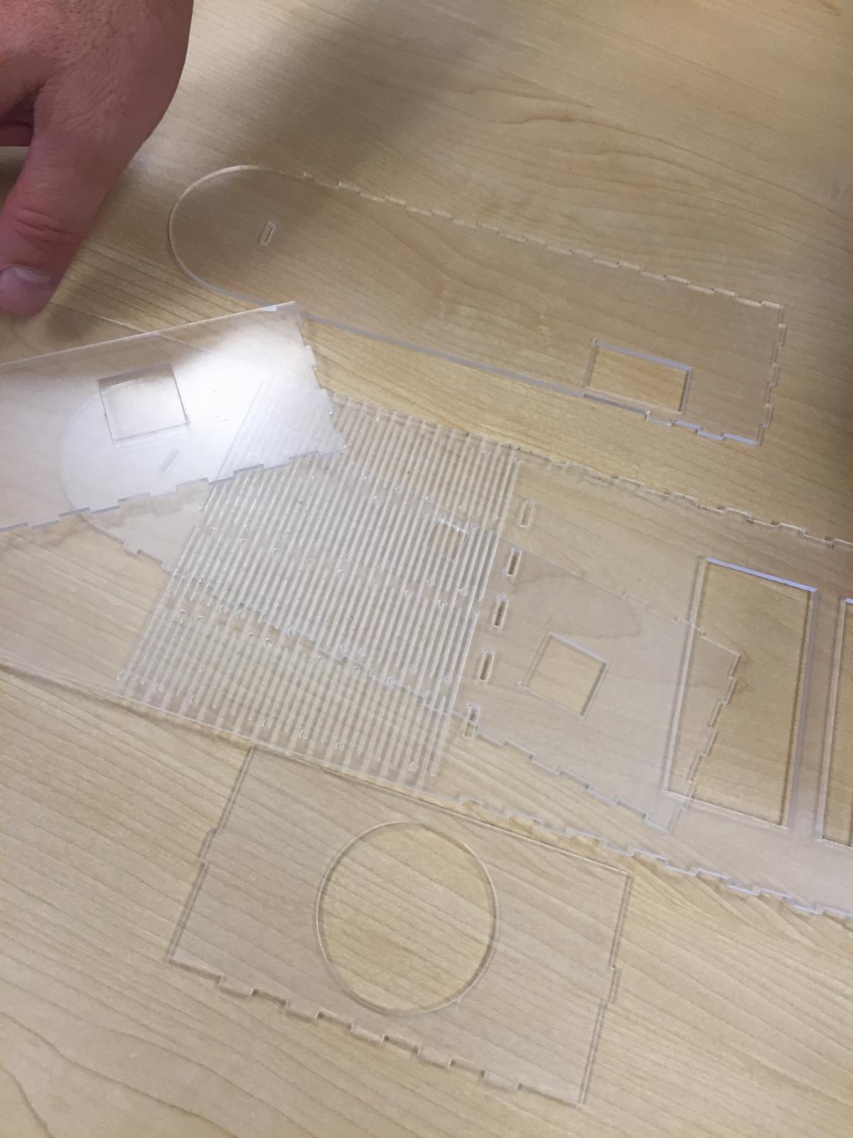 The laser-cut plexiglass pieces of the case