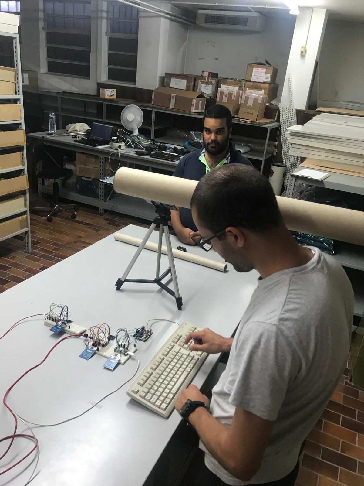 Hacking on the setup: typing on an old keyboard wired through breadboards and RF modules — part of the makeshift ubiquitous computer.