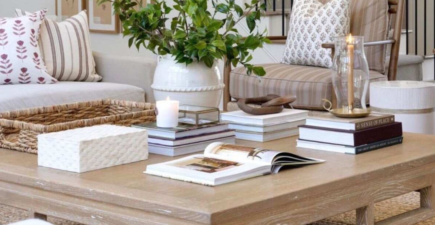 A coffee table stacked with design books, one lying open — the way these self-writing autobiographies are meant to be browsed.